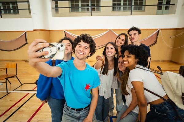 Um dos apresentadores tira uma selfie com um grupo de alunos.