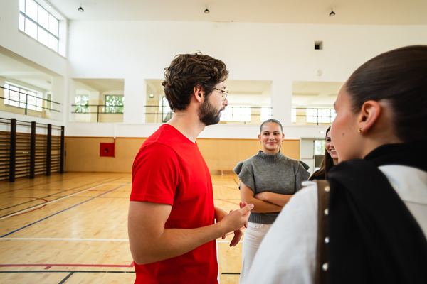 Um dos apresentadores conversa com duas alunas no pavilhão.
