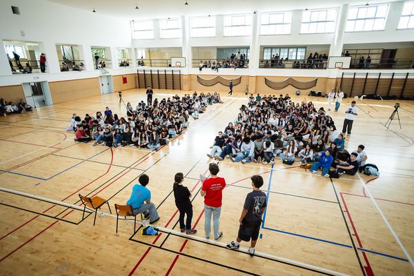 Vista de cima do pavilhão, com os alunos dispostos em torno dos apresentadores.